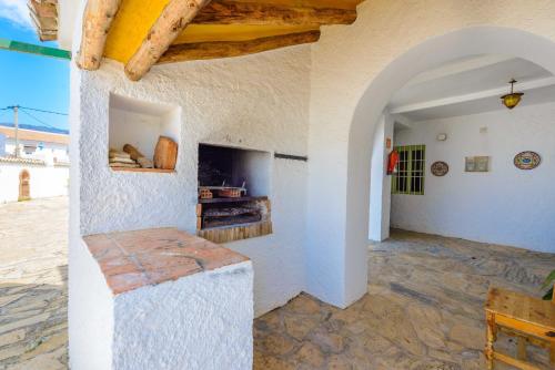 a room with a stone floor and an archway at Casa Jardin Del Olivar Für 18 Personen in Alcaucín