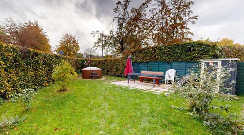 un jardin avec un banc et une table dans la pelouse dans l'établissement Eifel Oase, à Monschau