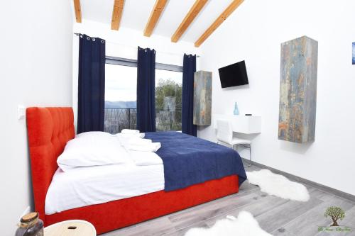 a bedroom with a bed and a desk and a window at La Finca Olivetree in Šestanovac