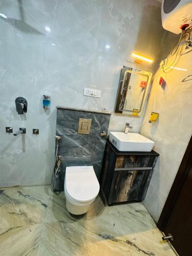 a bathroom with a toilet and a sink at Frankstay By Hotel Samrat Residency 10 Mints Walking Distance Nizamuddin Railway Station in New Delhi