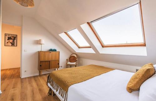 une chambre avec un lit et une grande fenêtre dans l'établissement Appartement centre-ville Reims vue Cathédrale, à Reims