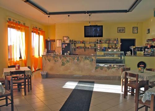 un restaurante con un bar con mesas y sillas en Ostello Del Volo, en Sigillo