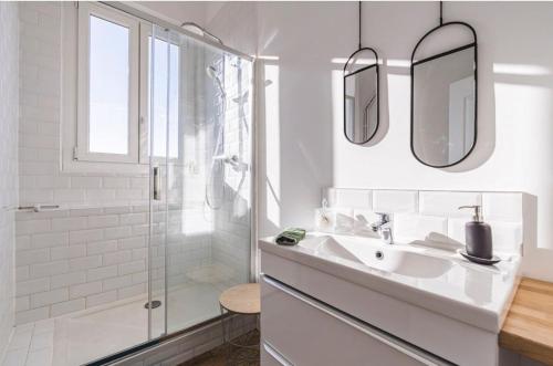 une salle de bain blanche avec un lavabo et une douche dans l'établissement Appartement centre-ville Reims vue Cathédrale, à Reims