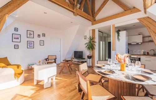 une salle à manger et un salon avec une table et des chaises dans l'établissement Appartement centre-ville Reims vue Cathédrale, à Reims