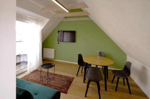 a room with a table and chairs and a green wall at Ferienwohnung In Söchau Mit Terrasse Und Grill in Söchau