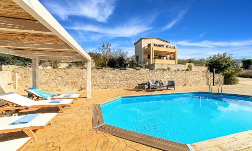 a swimming pool with chairs and a house at Ferienhaus Für 16 Personen In Episkopi, Kreta West Kreta in Episkopí- Rethimno