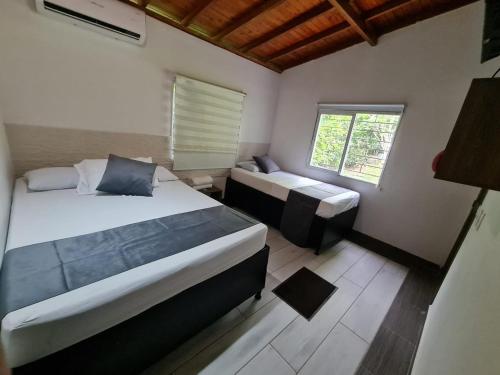 a small bedroom with two beds and a window at Finca Hotel Relax San Jerónimo in San Jerónimo