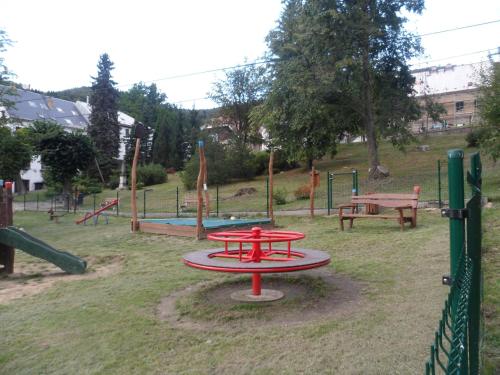 a playground with a red table in the grass at Pension Mikulka in Mikulov v Krušných Horách