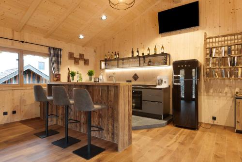 a kitchen with a bar with stools and a refrigerator at Ratscheinerhof App Gipfelglück in Lazfons