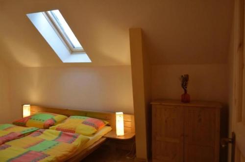 Un dormitorio con una cama y una claraboya. en Ferienhaus Haus Bärenstein In Naundorf Mit Grill, Terrasse, Sauna Und Kaminofen, en Struppen