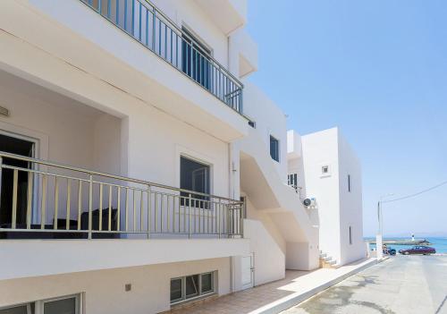 a white building with balconies on a street at Wohnung In Kato Gouves Mit Gemeinschaftspool in Kato Gouves