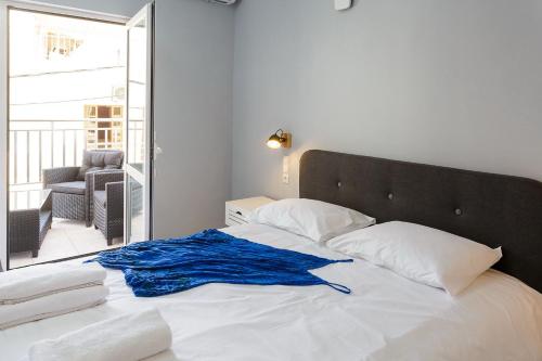 a white bed with a blue blanket on top of it at Wohnung In Kato Gouves Mit Gemeinschaftspool in Kato Gouves