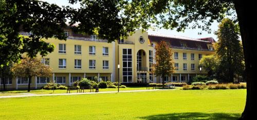 a large building with a green lawn in front of it at Parkhotel Green Garden in Bad Hersfeld