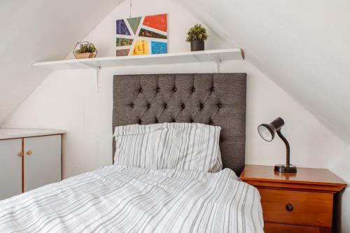 a bedroom with a bed with a headboard and a lamp at The Georgian House in Easingwold