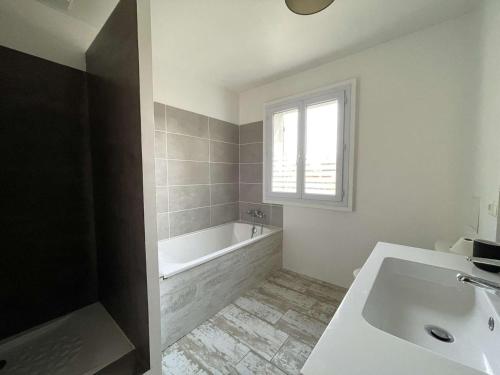 La salle de bains blanche est pourvue d'une baignoire et d'une fenêtre. dans l'établissement Villa T5 avec Piscine Privée, Proche Rivière, Wifi - FR-1-382-218, à Vallon-Pont-dʼArc