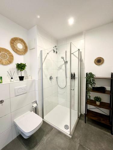 a white bathroom with a shower and a toilet at Spiritus Apartments in Augsburg