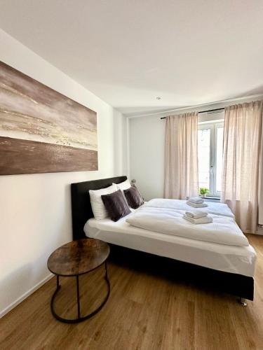 a bedroom with a large bed and a table at Spiritus Apartments in Augsburg