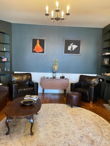 a living room with leather chairs and a table at The Yorkshire Inn in Phelps