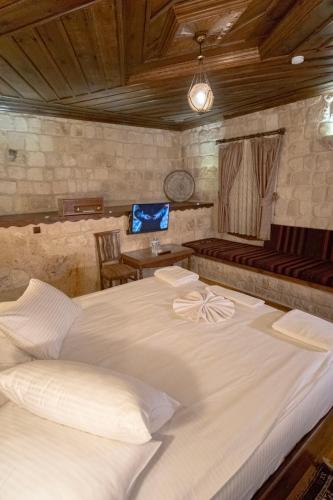 a large white bed sitting in a room at Kemerhan Cave Suites in Urgup
