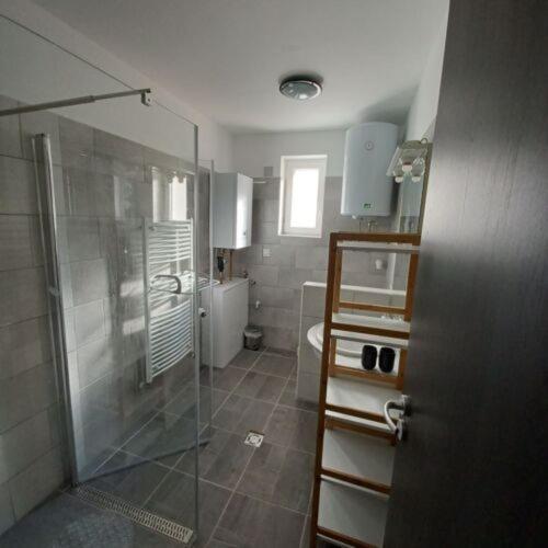 a bathroom with a glass shower and a toilet at The Other House, Piliscsaba in Piliscsaba