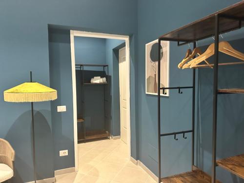 a room with a blue wall and a door with shoes at Sunset Palace Guesthouse in Reggio Calabria