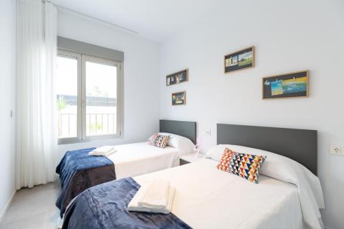 une chambre avec deux lits et une fenêtre dans l'établissement Margaritaville, à Pilar de la Horadada