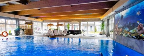 a large swimming pool in a large room at Srebrna Wydma Resort in Dąbki