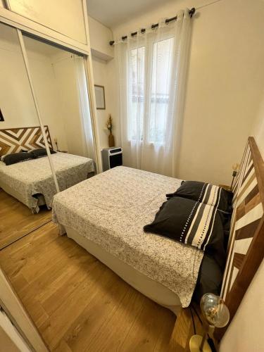 une chambre avec deux lits et un miroir dans l'établissement T2 centre ville de Nice face de la gare routière Nice ville, à Nice