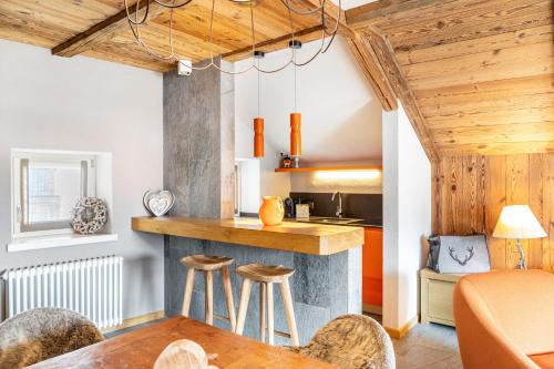 a kitchen and living room with a counter and stools at Haus Gabriel - Seefeld in Seefeld in Tirol