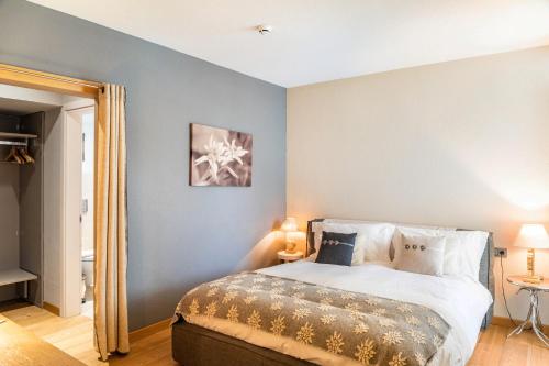 a bedroom with a large white bed with blue walls at Haus Gabriel - Seefeld in Seefeld in Tirol