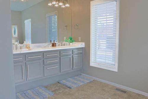 Un baño con dos lavabos y un espejo grande. en Golf Oasis Sleeps 22! Hot tub Firepit Gym Pool, en Omaha