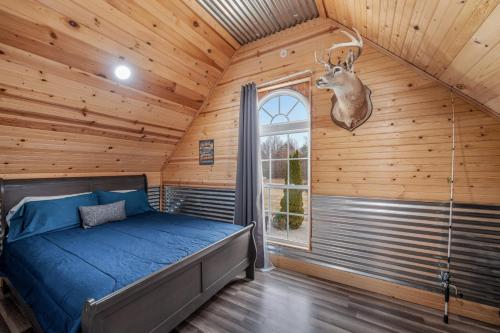 a bedroom with a bed and a deer head on the wall at Fall Foliage Retreat Hot Tub and Pond Deck in Bryant