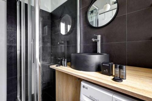 une salle de bain avec un lavabo et un miroir dans l'établissement BM-Un Eclat de Lumiere en Plein Paris, à Paris