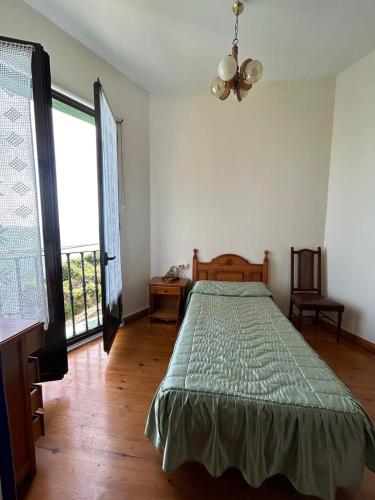 a bedroom with a bed and a large window at Balcon del Alba VUT N1238 in Lastres