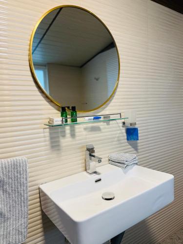 a bathroom with a white sink and a mirror at Medalin Harmony Heaven in Nuwara Eliya