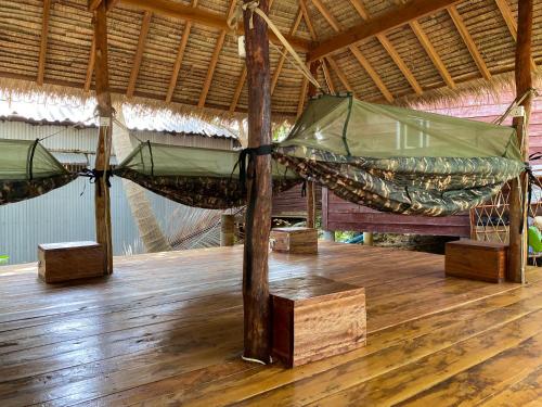 a room with two hammocks in a straw roof at Koalama Cambodia in Koh Rong Sanloem