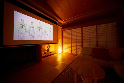 a living room with a tv and a couch at 鎌倉小町 大仏さまノ休日ホテル The Big Buddha Holiday Hotel Kamakura in Kamakura