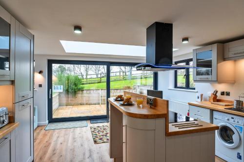 a kitchen with a sink and a dishwasher at Finest Retreats - Chasty House Barn in Holsworthy