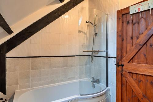 a bathroom with a bath tub and a shower at Finest Retreats - Chasty House Barn in Holsworthy
