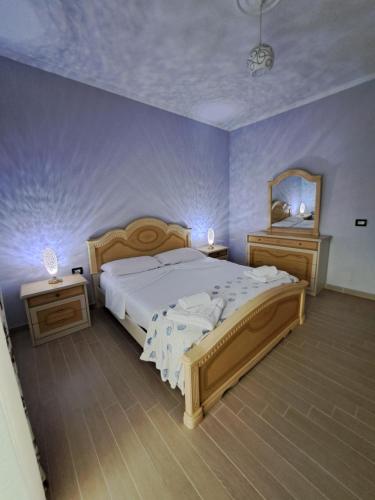 a bedroom with a large bed and a mirror at Gili & Delo luxury Apartments in Valjiosi