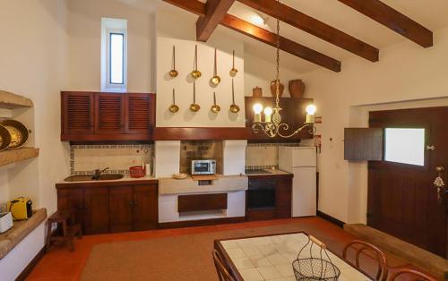 a kitchen with wooden cabinets and a table in a room at Herdade do Gamito in Crato