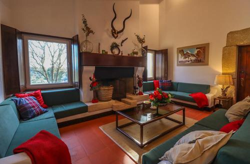 a living room with blue couches and a fireplace at Herdade do Gamito in Crato
