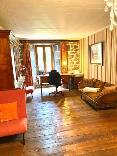 un salon avec un canapé et un bureau dans l'établissement Chambre avec du charme, à Saint-Martin-sous-Vigouroux