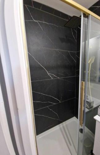- une porte de douche en verre avec une toile d'araignées dans l'établissement L'opale sauvage, à Wimereux