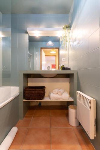 une salle de bain avec une baignoire, un lavabo et un miroir dans l'établissement Le Halle Aux Grains - Parking - Emplacement idéal, à Toulouse