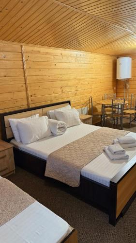 a bedroom with two beds and a table with chairs at Порядна Ґаздиня in Yaremche