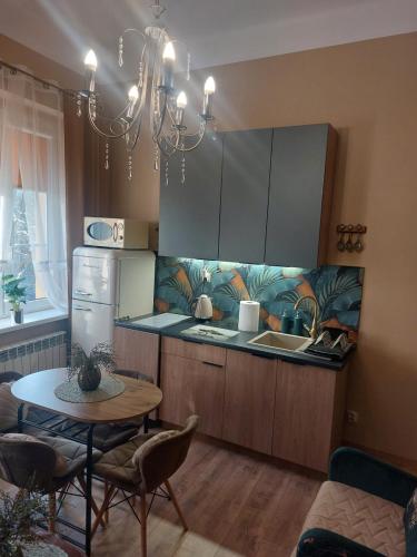 a kitchen with a table and a kitchen with a chandelier at Apartament przy ratuszu in Zielona Góra