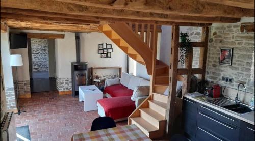 un salon avec un escalier dans une maison dans l'établissement Charmante maison de campagne, à Yvignac