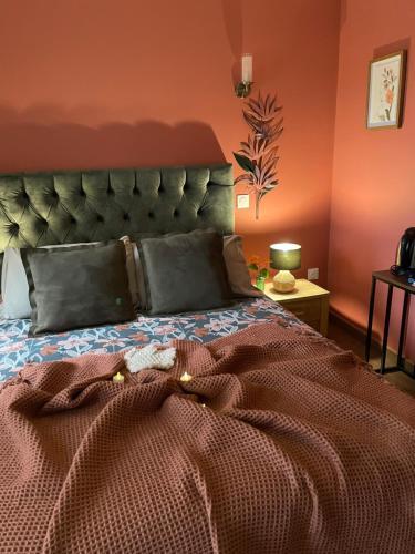 une chambre avec un grand lit avec un mur orange dans l'établissement Chambre cosy, à Saint-Amand-les-Eaux