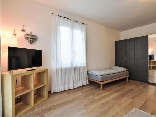 a living room with a flat screen tv next to a window at Studio San Anton by Interhome in Bormio